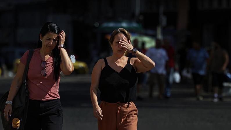Pessoas se protegem do sol no centro da cidade em dia de calor no Rio de Janeiro. Foto: Fernando Frazão/Agência Brasil