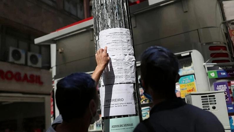 Pessoas observam anúncios de emprego em poste de luz no centro de São Paulo
