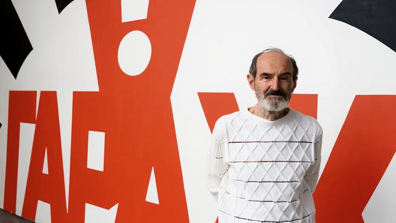 Erik Bulatov pictured in 2016 with a large-scale work he created for the Garage Contemporary Art Museum in Moscow
