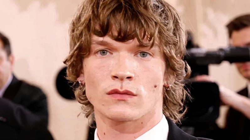 “Heated Rivalry” star Connor Storrie hit the Golden Globes 2026 red carpet in retro style on Sunday.