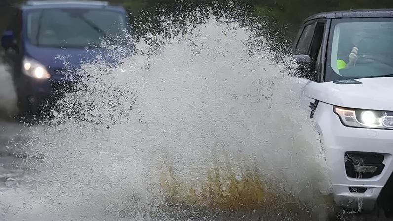 Vehicles travel through areas of flooding.