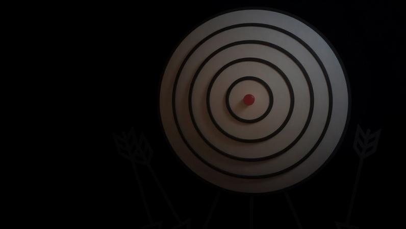 Arrow laying on the ground next to a target