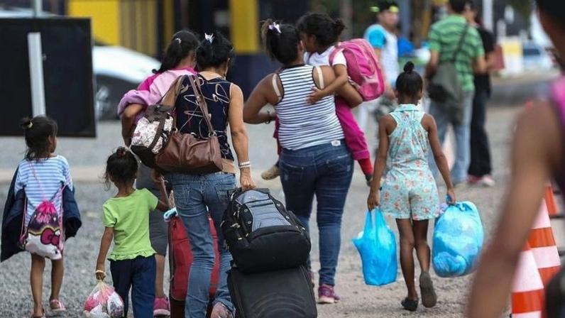 Imigrantes e refugiados venezuelanos cruzam a fronteira em Pacaraima, em Roraima