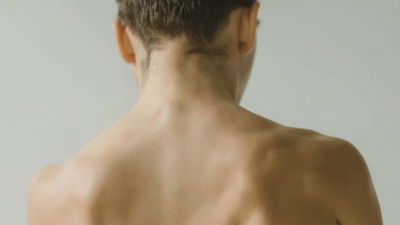 A pixelated image of a woman's neck and shoulders.