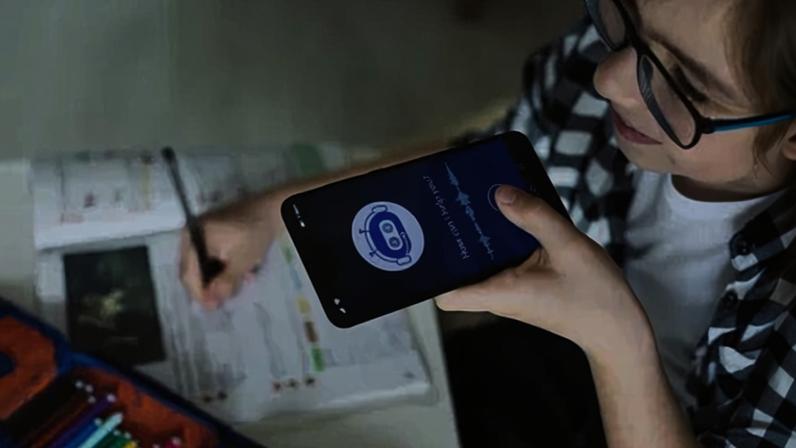 Happy boy using system AI Chatbot on mobile application to do his homework. Chatbot conversation, Ai Artificial Intelligence technology. Futuristic technology. Virtual assistant on internet.