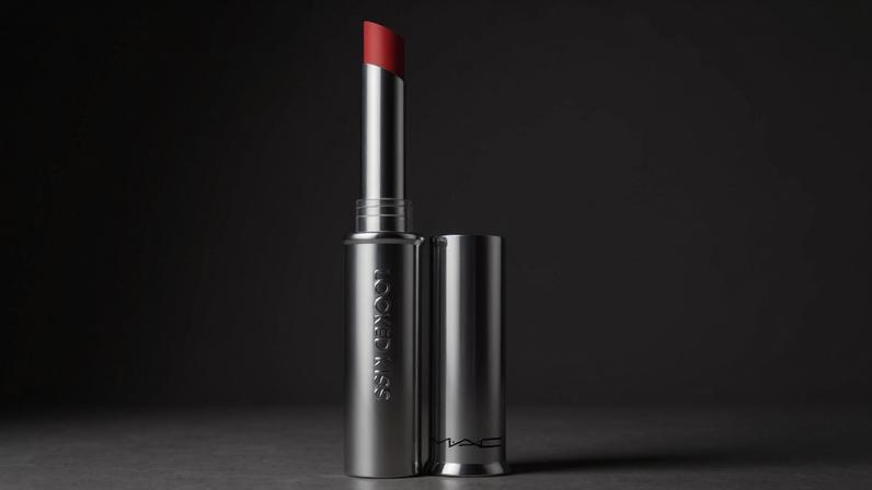 MAC Locked Kiss Lipstick in Ruby True, a red lipstick in a silver tube with its cap off.
