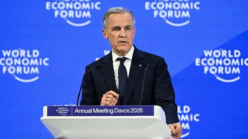 Carney stands at a lectern in front of a blue backdrop featuring the World Economic Forum logo.
