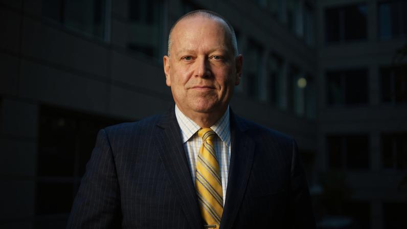 Michael Moody stands outside an office building on a sunny day