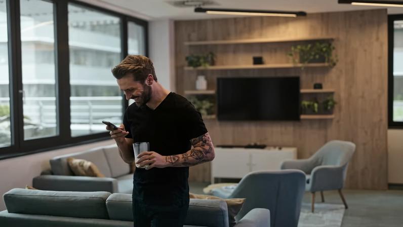 Homem usa o celular na sala de uma casa — Foto: Andrea Piacquadio/Pexels