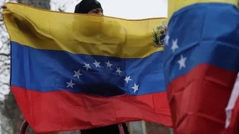 Pessoas seguram bandeiras da Venezuela