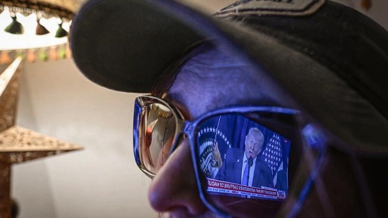 A woman in Krakow, Poland, watches U.S. President Donald Trump on Fox News on Jan. 3 following the U.S. military raid that led to the capture of Venezuelan President Nicolás Maduro.