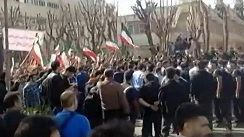 Esta captura de vídeo, extraída de imagens geradas por usuários postadas em redes sociais e verificadas pelas equipes da AFPTV em Paris em 21 de fevereiro de 2026, mostra iranianos em confronto perto do Departamento de Engenharia Aeroespacial da Universidade Sharif, em Teerã. Enquanto alguns repetem "vergonhoso" em farsi, um cântico comum em protestos antigovernamentais, outros agitam a bandeira da República Islâmica do Irã. Estudantes iranianos entoaram slogans antigovernamentais em manifestações em memória das pessoas mortas durante uma recente onda de protestos, conforme noticiado pela mídia local e da diáspora em 21 de fevereiro de 2026, quando grupos que protestavam contra a liderança clerical se confrontaram com outros que manifestavam apoio ao governo. Foto por UGC / AFP