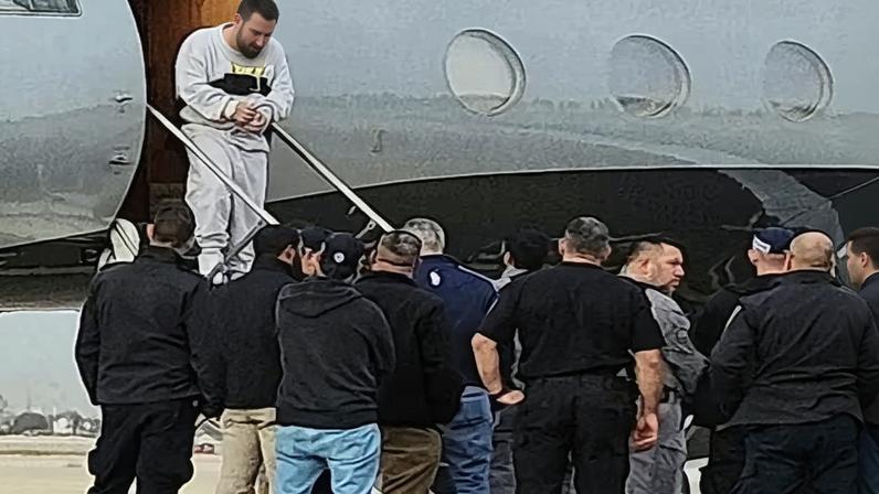 Israeli security personnel receive a handcuffed Palestinian deported from the United States at Israel's Ben-Gurion international airport. The plane made refuelling stops at Shannon airport.