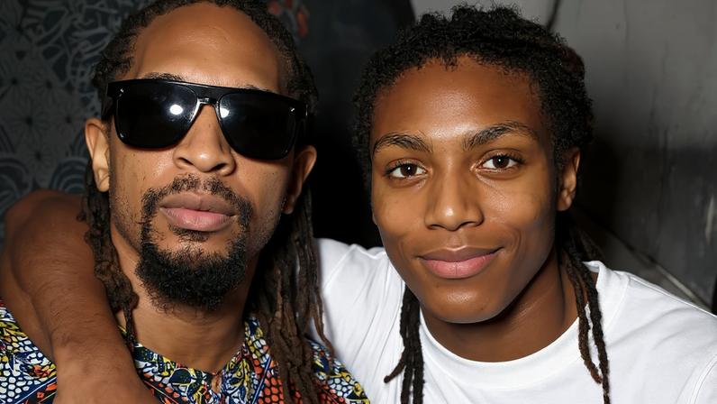 Lil Jon wearing a Baltimore Ravens beanie, sunglasses, and jacket.