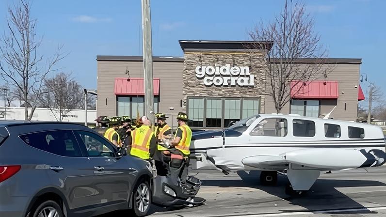 Rescue workers operate near a damaged vehicle and a small plane after the plane landed in a roadway, in Gainesville, Georgia on 9 February 2026.