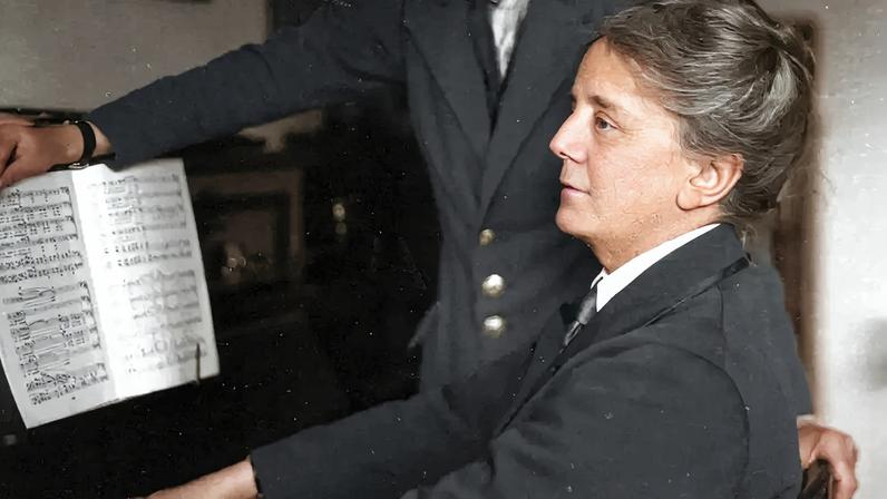 Fotografia da Dame Maria Ethel Smyth tocando piano.