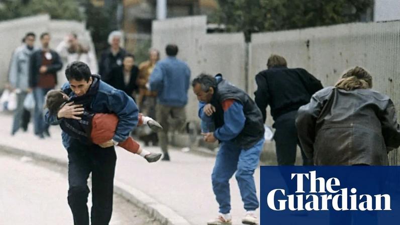 A man cradles his child as people run past one of the worst spots for snipers in Sarajevo in April 1993.