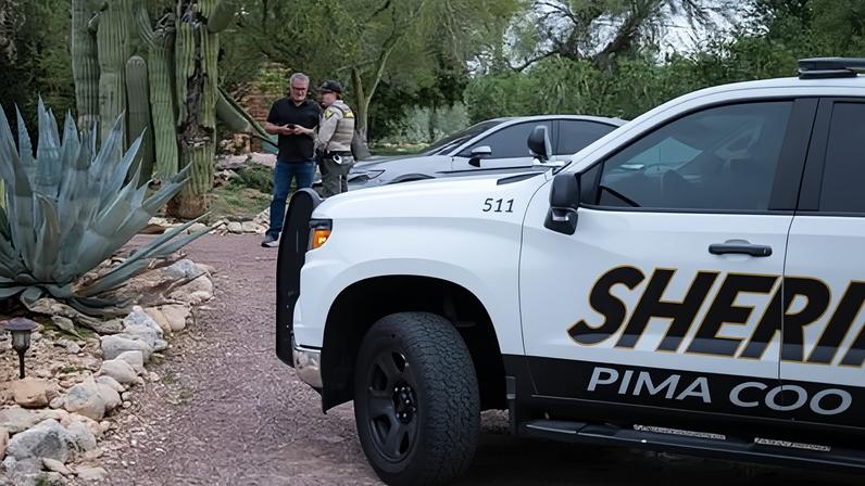 A Pima county sheriff's deputy talks with a private security guard at Nancy Guthrie's home on 5 February 2026 in Tucson, Arizona.
