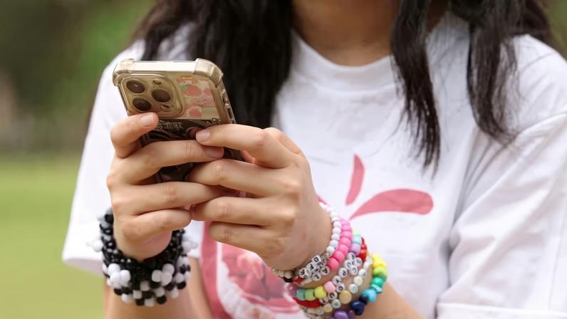 Imagem ilustrativa mostra jovem, não identificada, com um celular nas mãos — Foto: Hollie Adams/Reuters