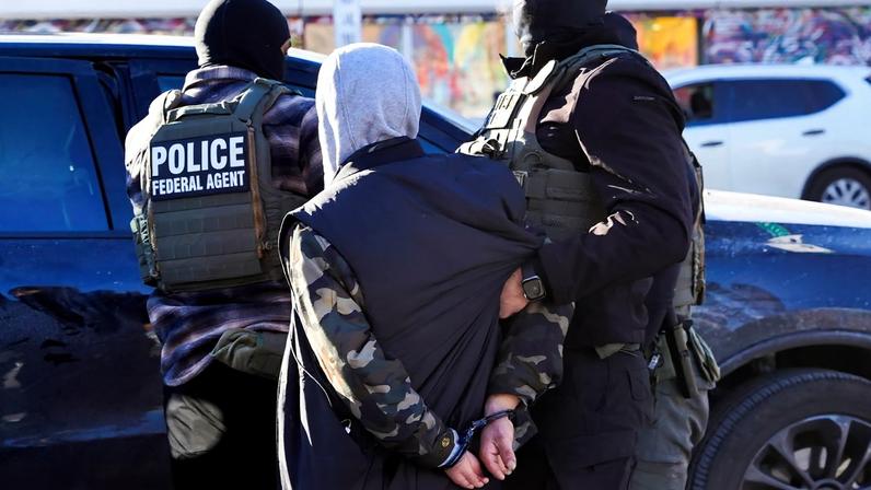FILE PHOTO: Federal agents detain a person at a bus stop as they conduct an immigration raid days after a U.S. Immigration and Customs Enforcement (ICE) agent fatally shot Renee Nicole Good, in Minneapolis, Minnesota, U.S., January 14, 2026. REUTERS/Ryan Murphy/File Photo