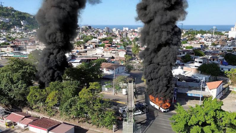 Smoke billows from burning vehicles amid a wave of violence, with torched vehicles and gunmen blocking highways in more than half a dozen states, following a military operation in which a government source said Mexican drug lord Nemesio Oseguera, known as "El Mencho," was killed, in Puerto Vallarta, Jalisco, Mexico, February 22, 2026, in this screen grab obtained from a social media video.