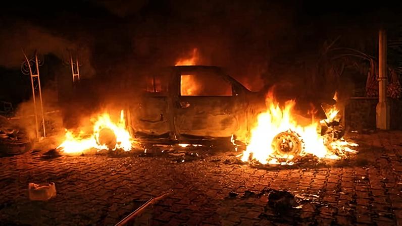 A vehicle is engulfed in flames after it was set on fire inside the US consulate compound in Benghazi on 11 September 2012.