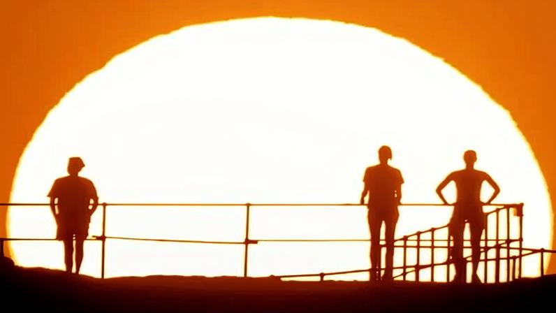 People watch as the sun rises over Ben Buckler Point in Bondi Sydney, Australia, duri a heatwave in November 2024