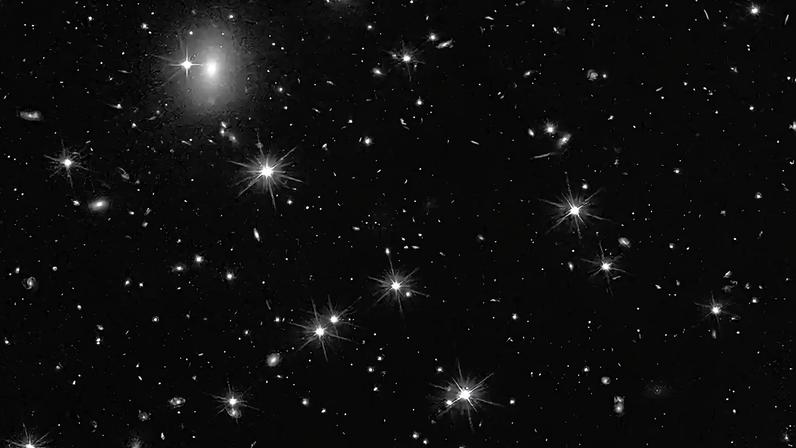 Utilizando o Telescópio Espacial Hubble em conjunto com outros observatórios, astrônomos identificaram uma galáxia excepcionalmente tênue, conhecida como candidata a galáxia escura-2, que parece ser quase inteiramente dominada por matéria escura.
