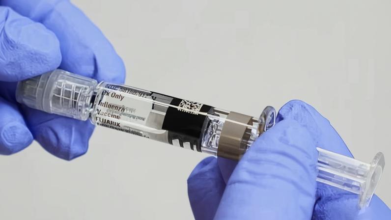 A medical professional in Seattle holds a syringe for a flu vaccine.
