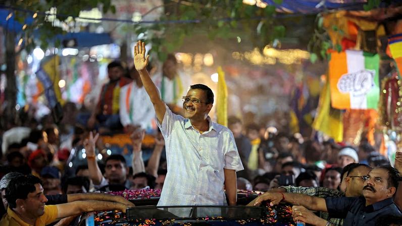 People gather as Delhi's Chief Minister Arvind Kejriwal attends a roadshow, in New Delhi