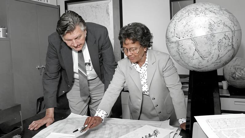 Imagem mostrando Gladys West e Sam Smith olhando dados do sistema de posicionamento global.
