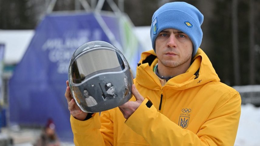 Vladyslav Heraskevych with his helmet, featuring portraits of 21 athletes killed in the conflict with Russia