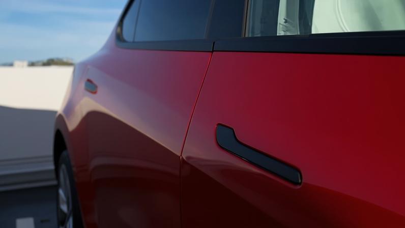 A door handle on a red Tesla Model Y.