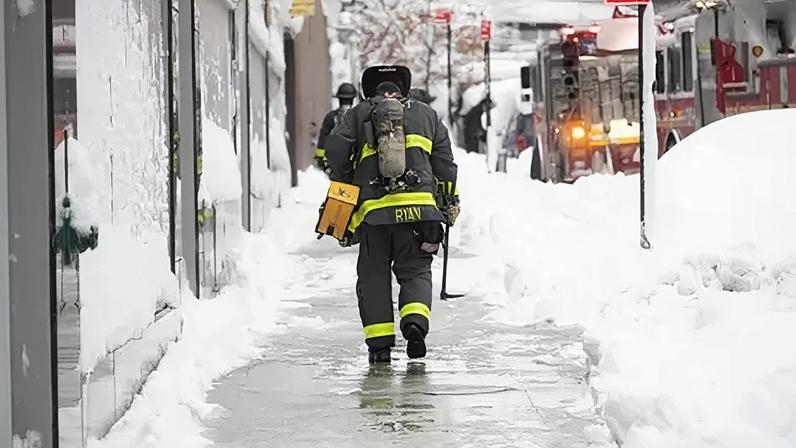 A firefighter walks through the winter storm