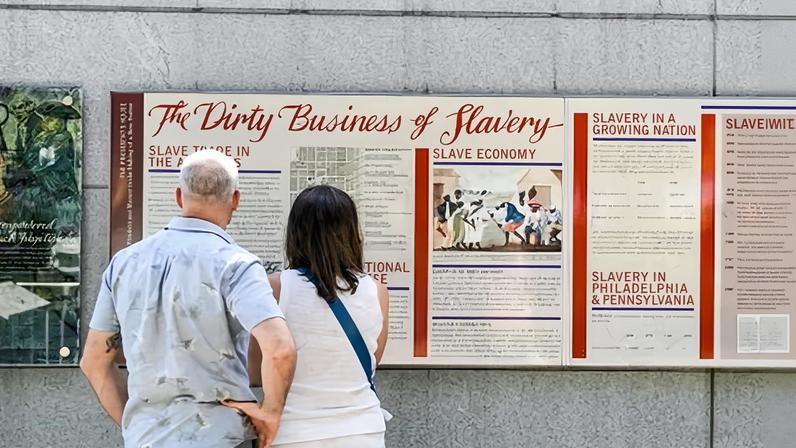 Tourists inspect a display entitled 'The Dirty Business of Slavery' at the President's House on 9 August 2025 in Philadelphia, Pennsylvania.