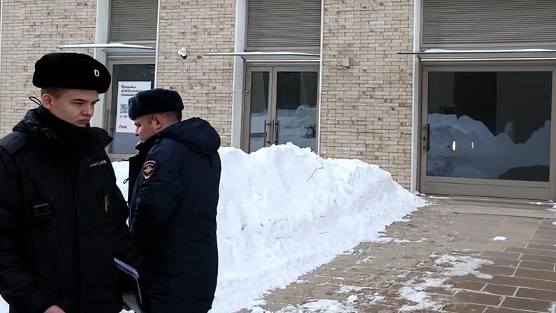 Russian police officers stand next to the entrance of a residential building in Moscow where Vladimir Alekseyev was shot on Friday.