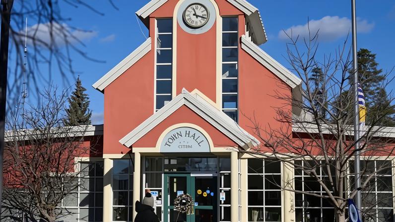 A person looks at flowers on the steps of the town hall