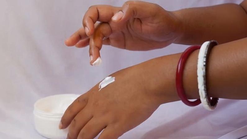 Closeup of a woman applying cream to her hand