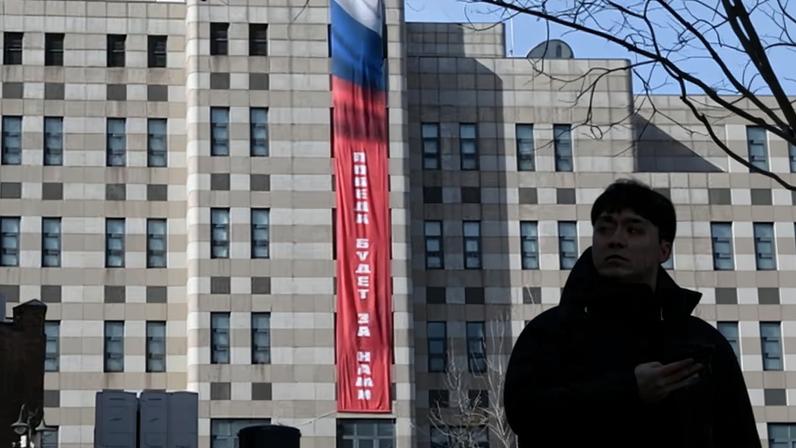 A man walks in front of the Russian embassy in Seoul, South Korea, as a Russian-language banner saying ‘Victory will be ours’ is displayed on Monday.