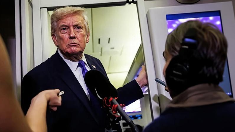 Trump speaks to reporters on Air Force One on the way to Mar-a-Lago on Friday.