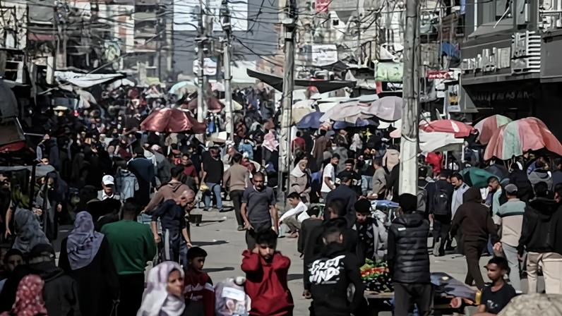 People buy and sell items at market stalls in the Nuseirat refugee camp, near Deir al-Balah.