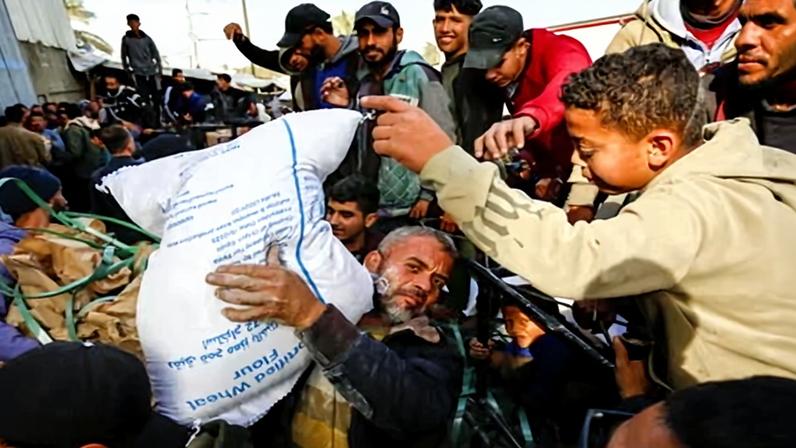 Displaced Palestinians, including children, receive flour and food packages distributed by the United Nations World Food Programme.