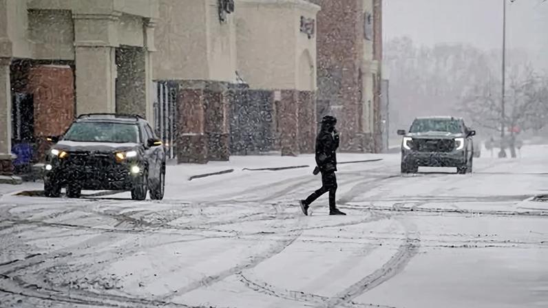 A person walks through a snow-covered parking lot in Brentwood, Tennessee, on 24 January 2026.