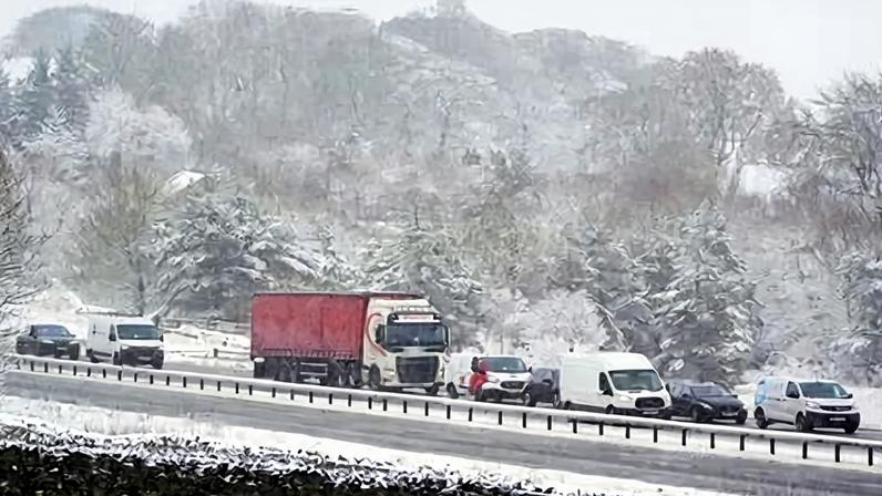 Cars and lorries queue on the A66 at Bowes after it was closed. Yellow weather warnings for snow and ice remain in force across parts of the UK.