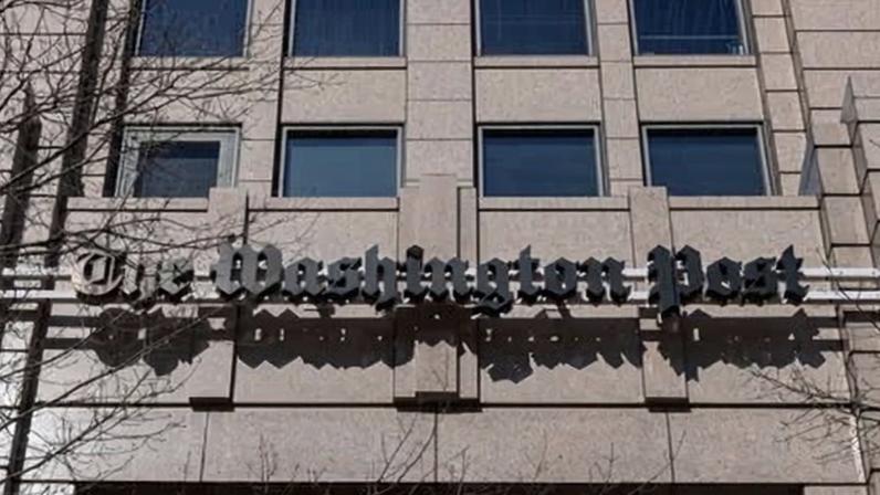 The Washington Post building sign is seen during a rally outside the newspaper's offices following sweeping layoffs.
