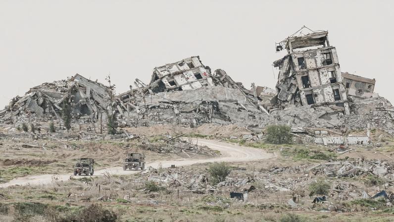 Israeli military vehicles drive past destruction in Gaza, as seen from the Israeli side of the Israel-Gaza border in southern Israel, January 21, 2026. REUTERS/Amir Cohen/File Photo
