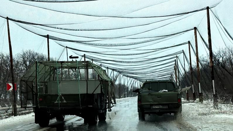 Service members of the 93rd Kholodnyi Yar Separate Mechanized Brigade of the Ukrainian Armed Forces ride a military vehicle, with a grille installed for combat drones protection, along a road covered with anti-drone net, amid Russia's attack on Ukraine, near the frontline town of Kostiantynivka in Donetsk region, Ukraine February 19, 2026. Picture taken with a mobile phone.