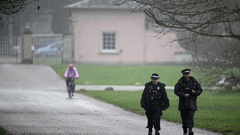 Police officers walk on the driveway to the gates of Royal Lodge, Andrew Mountbatten-Windsor's former residence in Windsor Great Park, on Friday 20 February.