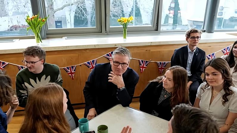 Starmer sitting at a table on a visit to a community centre at St Mary's church in Putney on Monday.