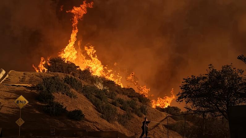 A firefighter battles the Palisades fire in Mandeville Canyon, 11 January 2025, in Los Angeles.